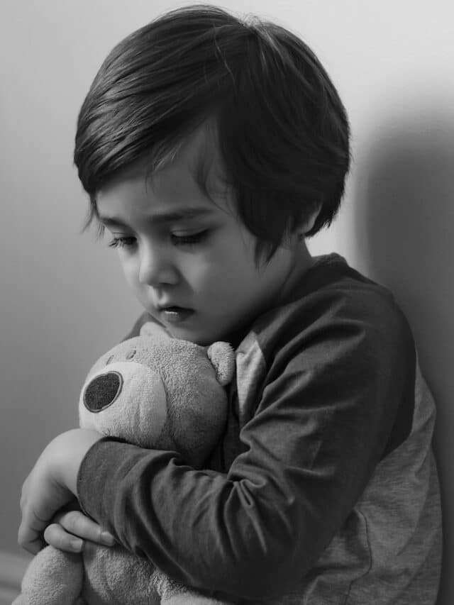 Sad,Boy,Wearing,Pyjamas,Cuddle,Teddy,Bear,Sitting,At,Corner