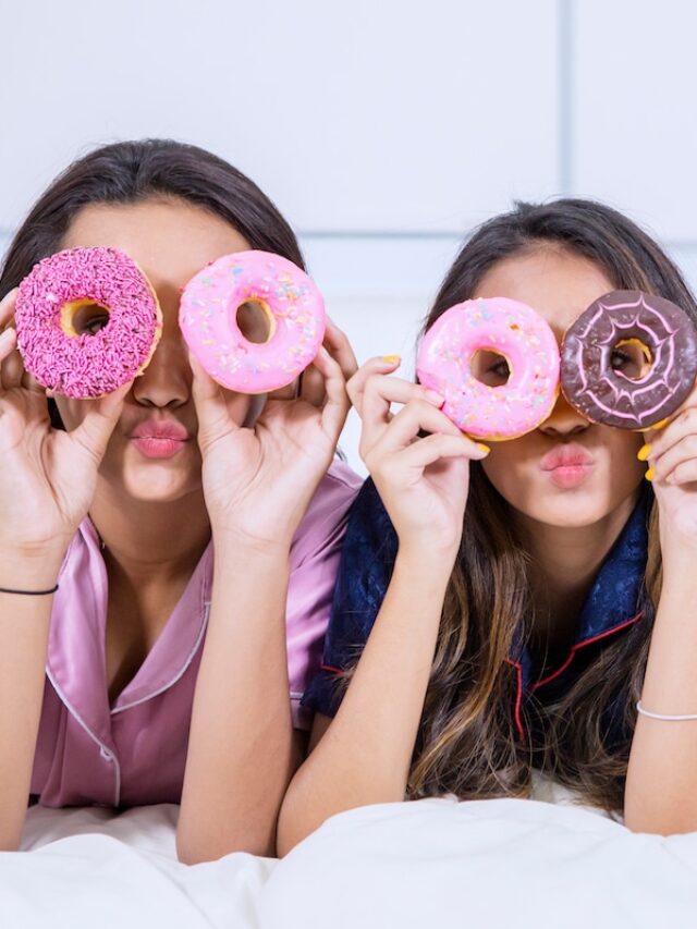 Group,Of,Teenage,Girls,Covering,Their,Eyes,With,Donuts,While