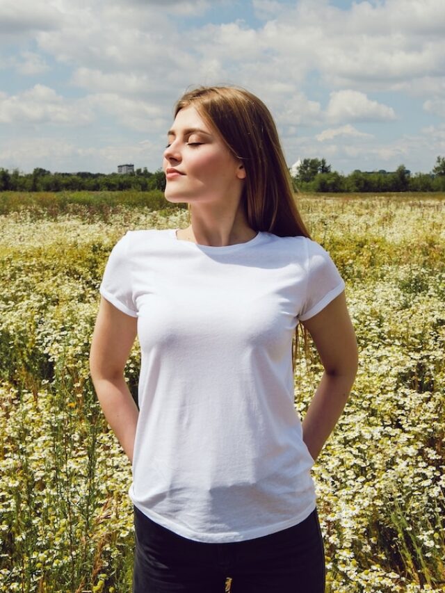 Happy,Young,Woman,In,White,T-shirt,Stands,In,Chamomile,Field.