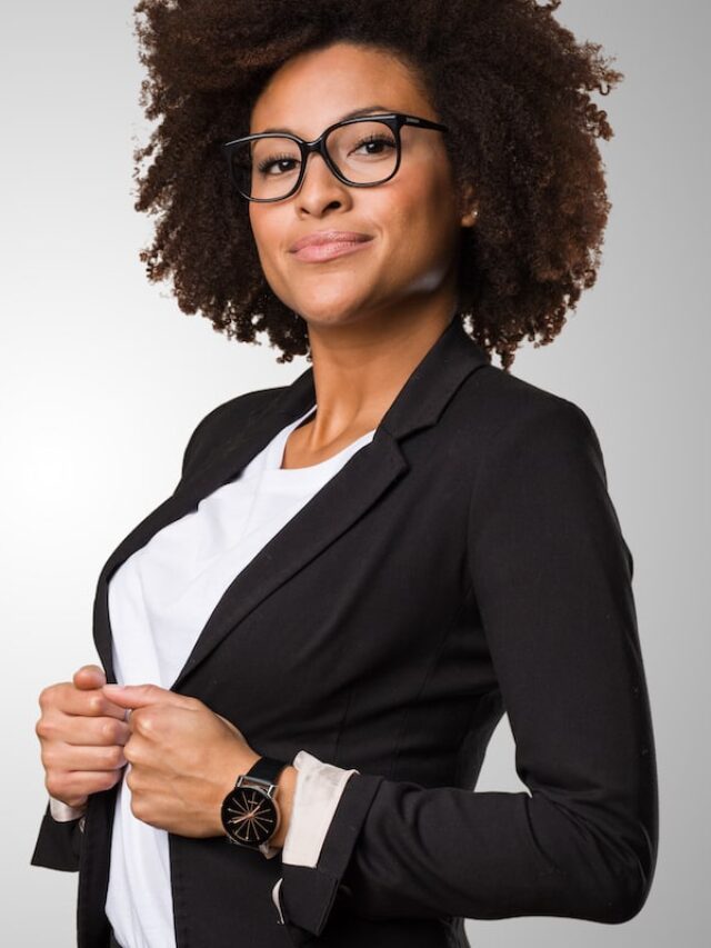 Business,Black,Woman,Adjusting,Her,Clothes,On,A,Grey,Background