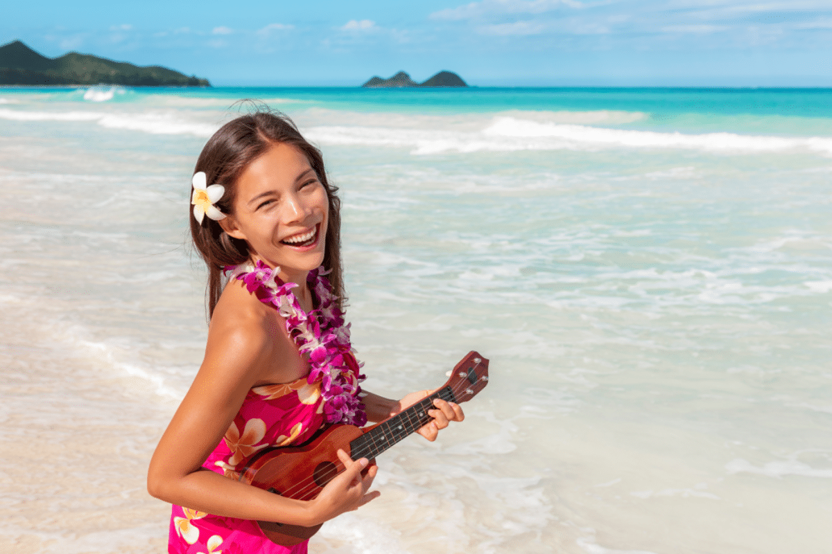 Hawaii luau ukulele hula dancing woman playing guitar on beach vacation