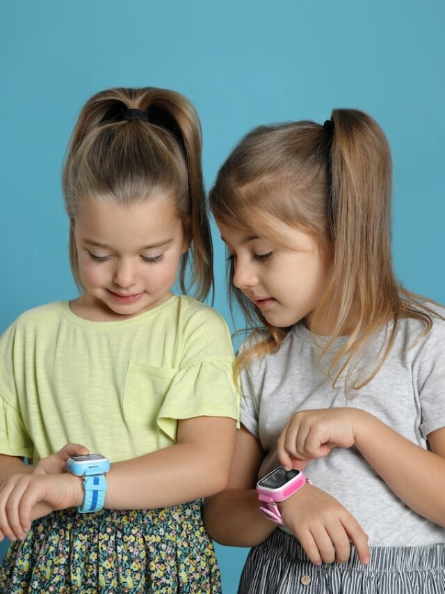 Little,Girls,With,Smart,Watches,On,Light,Blue,Background